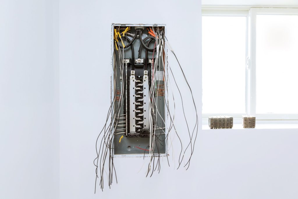 An open household breaker panel with its circuits and wiring exposed