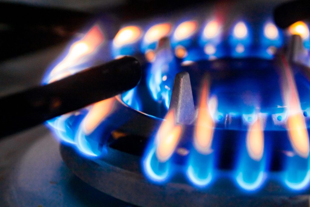 A gas burner alight with mixed blue and orange flames