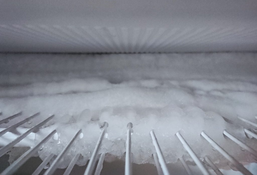 Heavy frost built up over the evaporator grille inside a freezer