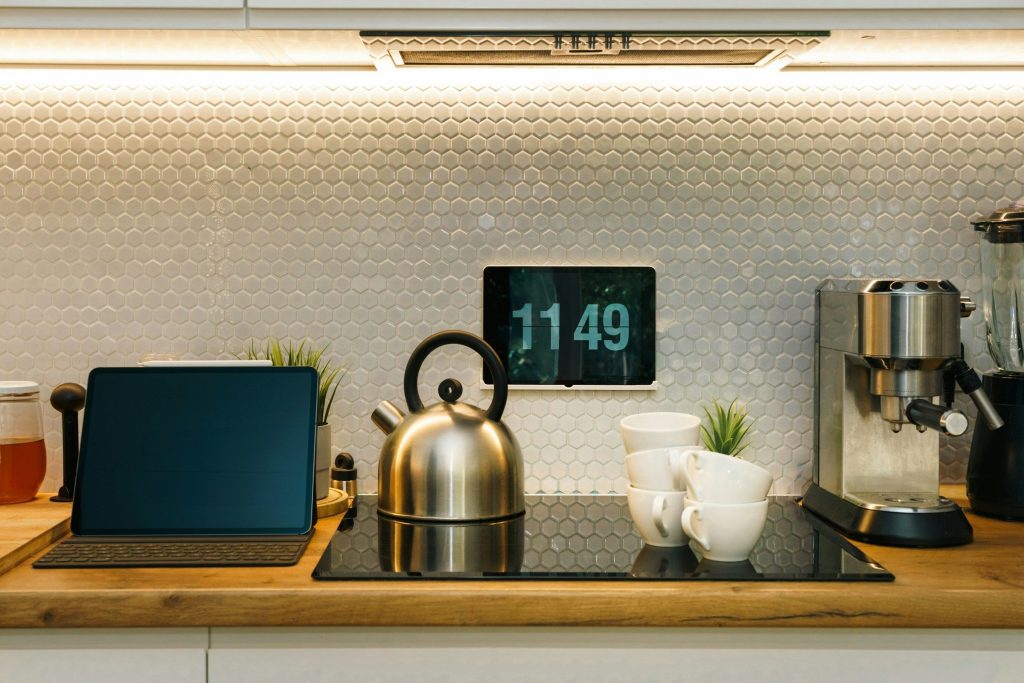 A domestic induction hob set into a wooden counter, with a kettle standing on it