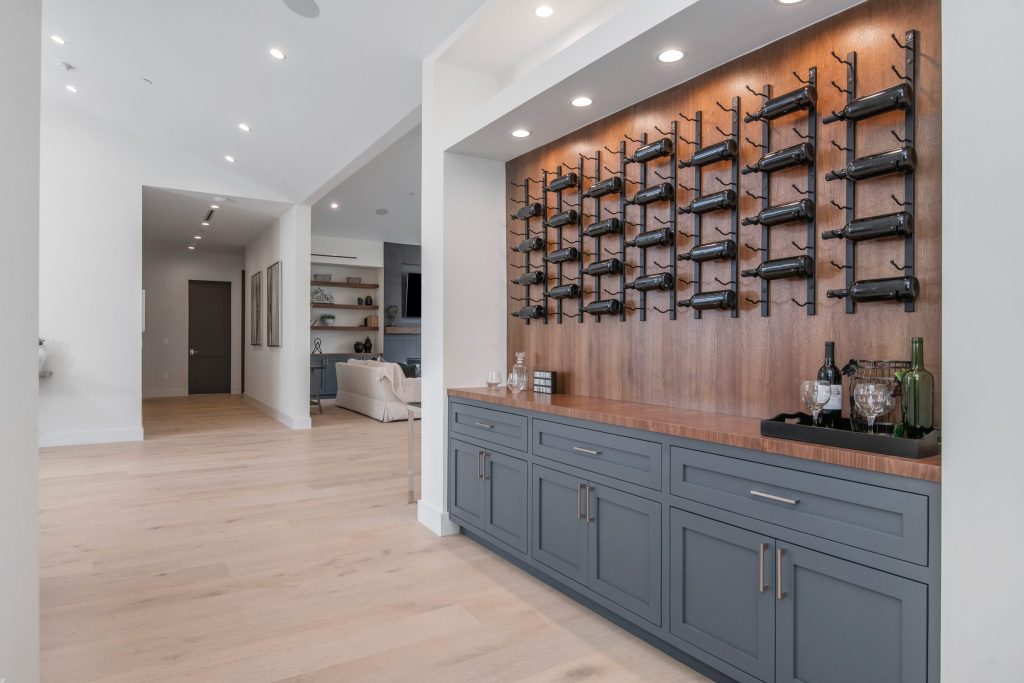A wall of wine racking above a run of grey base cabinets