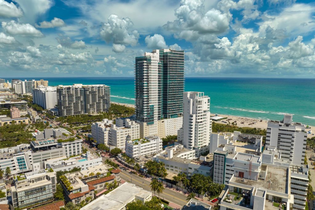 Beachfront towers and low blocks along the ocean, seen from the air