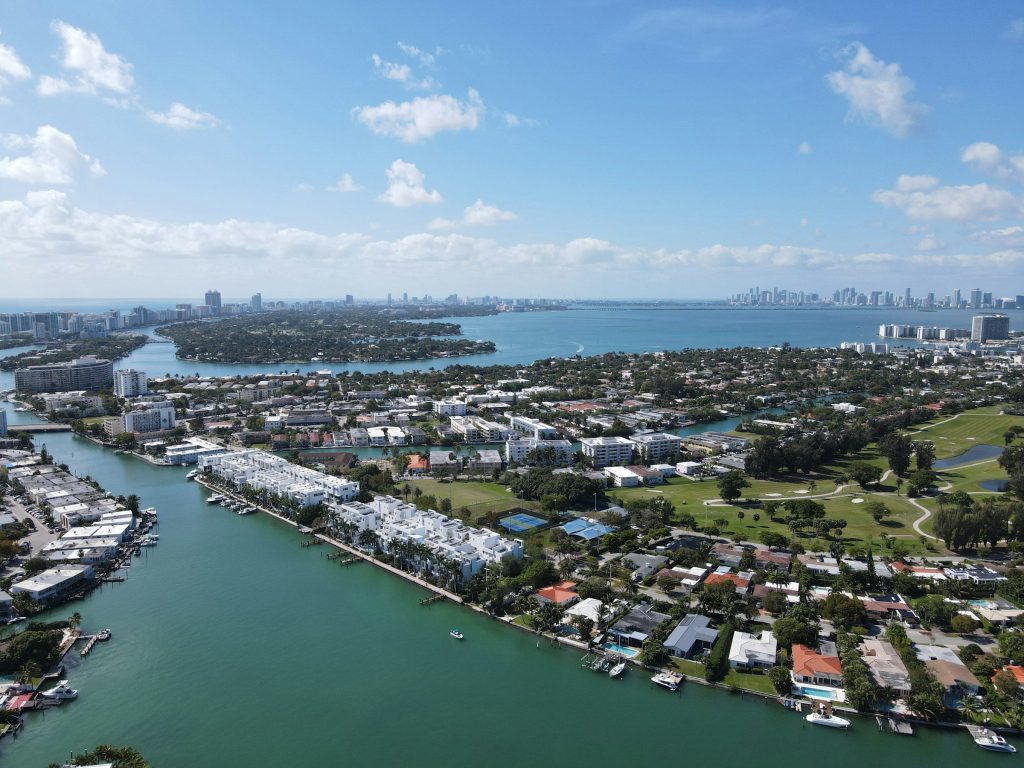 A waterfront neighborhood with a marina and low houses, mid-rise blocks and a distant skyline