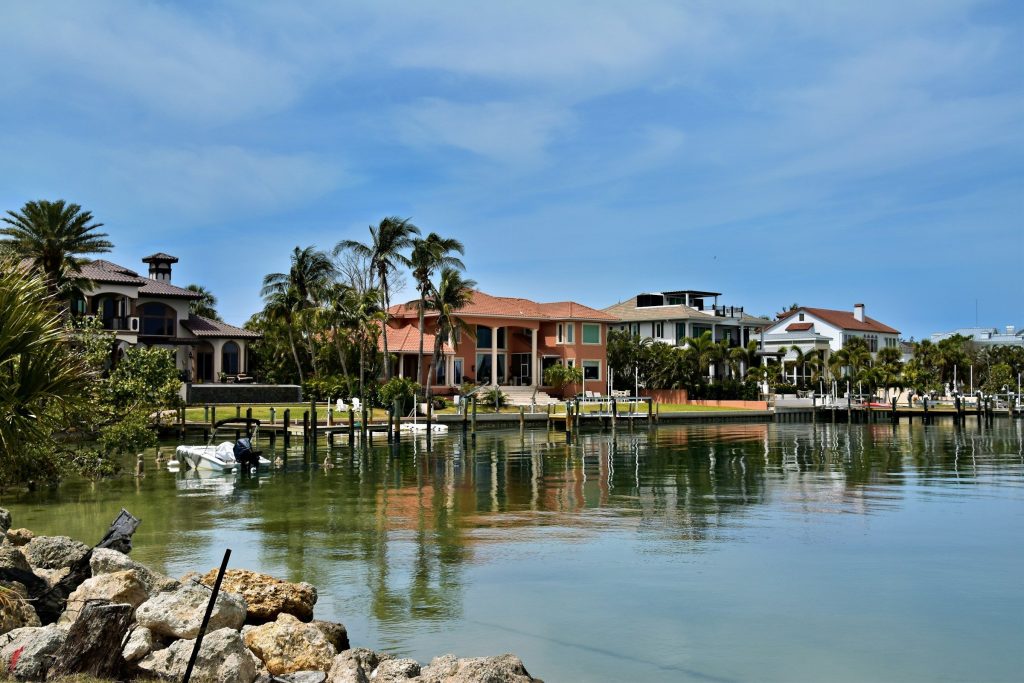 A row of waterfront houses of different ages and sizes across a basin