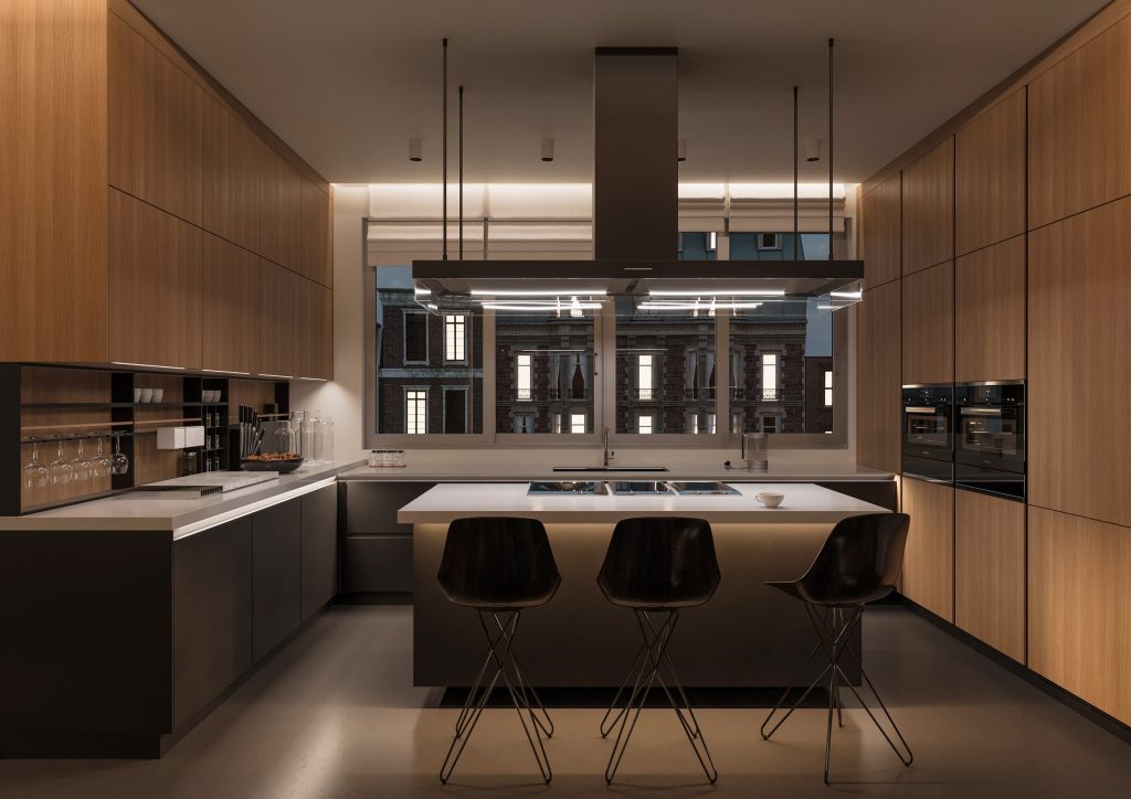 A walnut-panelled kitchen at night, an island with three stools under a linear hood and a city window behind