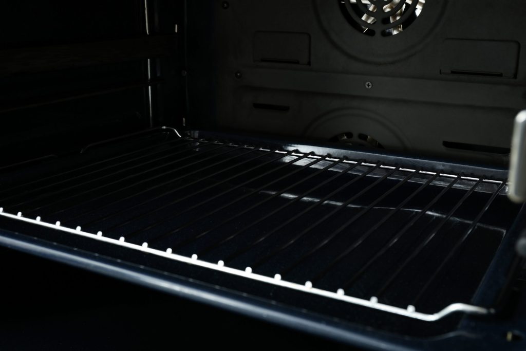 The dark interior of an oven with its rack in place, seen from the open door